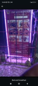 Un cartel delante de una puerta con comida y desayuno. en Fafaco border guesthouse, en Amdallai