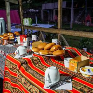 a table with a table cloth with a plate of food at Yawar inka ayllu challhuay in Colcapampa