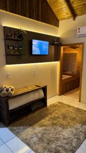 a living room with a flat screen tv on the wall at Pousada dos Canyons - chalé 01 in Praia Grande