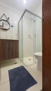 a bathroom with a shower and a toilet and a sink at Apartamento com Prédio Frente Mar in Praia Grande