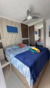 a bedroom with a large bed with a blue blanket at Apartamento com Prédio Frente Mar in Praia Grande