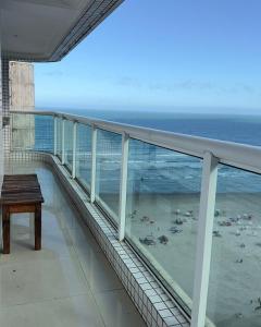 a balcony with a table and a view of the beach at Apartamento com Prédio Frente Mar in Praia Grande