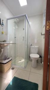 a bathroom with a glass shower and a toilet at Apartamento com Prédio Frente Mar in Praia Grande +7 photos