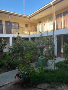 a courtyard with a fountain in front of a building at Hostal CECIL + in Vallenar