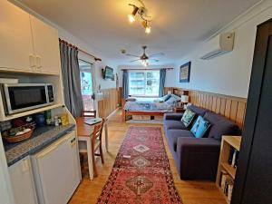 una sala de estar con un sofá y una mesa en North Durras Beach Cottage, en Durras