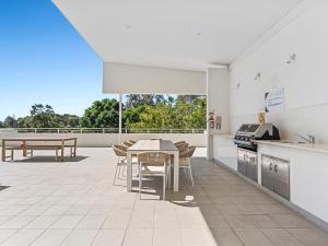 an open kitchen and dining room with a table at Stylish 3 Bedroom Apartment with Pool, Sauna & Gym in Gold Coast