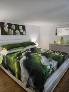 a bedroom with a bed with a green comforter at La Casa di Teo Sorrento Coast in Sant'Agnello