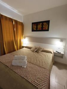 ein Hotelzimmer mit einem Bett, auf dem zwei Handtücher liegen in der Unterkunft SUEÑOS DE TERMAS in Chajarí