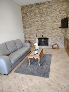 a living room with a couch and a fireplace at Casa das Pedras in Vieira do Minho