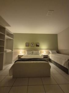 阿拉卡蒂Residencial New Stilo-Coral的一间大卧室,配有两张床和两盏灯。