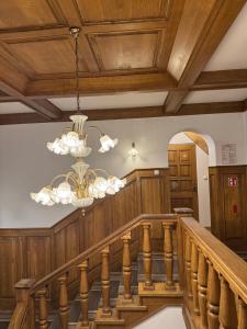 a staircase with a chandelier and wooden ceiling at Hotel Familiar in Kobyłka +40 photos