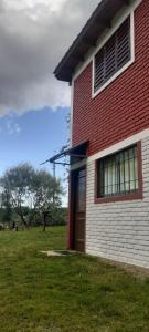 un edificio rojo y blanco con una puerta roja en Del carmen chica, en Villa Giardino