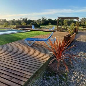 a wooden deck with a chair and a pool at Domo Tunquen in Tunquén