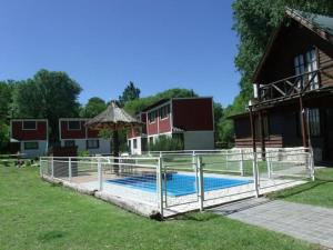 una valla alrededor de una piscina frente a un edificio en Del carmen chica, en Villa Giardino