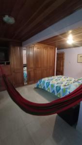 eine Hängematte in einem Schlafzimmer mit einem Bett in der Unterkunft Casa La Carmela in Cota