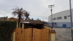 ein Haus mit einem Holzzaun und einer Palme in der Unterkunft Casa La Carmela in Cota