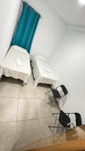 Habitación con 2 sillas, mesa y cortina azul en Buena Vista, en Arinaga