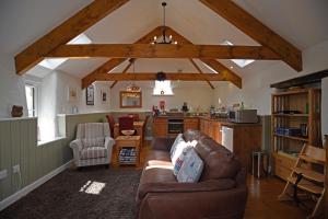a living room with a couch and a kitchen at The Mowhay tranquil farm stay with views in Redruth