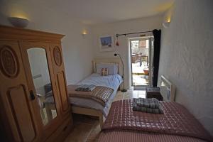 a small bedroom with two beds and a mirror at The Mowhay tranquil farm stay with views in Redruth