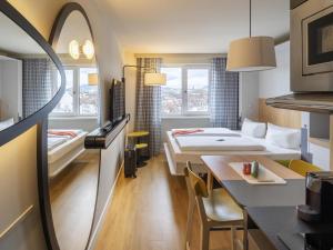 una habitación de hotel con dos camas y una mesa en Aparthotel Adagio Access Freiburg, en Freiburg im Breisgau