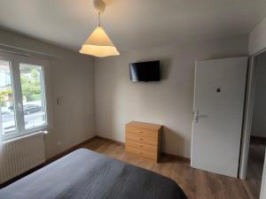 a bedroom with a bed and a tv on the wall at Notre Dame d'Orgemont - Marron 6 in Argenteuil