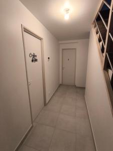 un couloir vide avec une porte et du carrelage dans l'établissement Notre Dame d'Orgemont - Marron 6, à Argenteuil