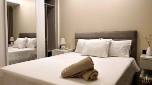 a bedroom with a white bed with a towel on it at Serenity in Praia +23 photos