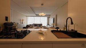 a kitchen and living room with a stove and a sink at Serenity in Praia