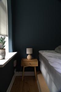 a bedroom with a bed and a table with a lamp at Green Brook - Blue Suite in Aalborg +18 photos