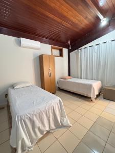 a bedroom with two beds and a wooden ceiling at Hotel pousada Janaúba in Janaúba +93 photos
