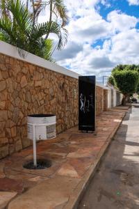 a stone wall with a mailbox next to a street at Hotel pousada Janaúba in Janaúba