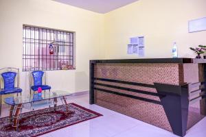 a room with two blue chairs and a glass table at Hotel O Sarala Residency in Bārang