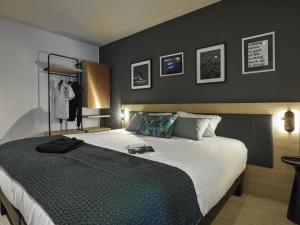 1 dormitorio con 1 cama grande y pared negra en Aparthotel & Spa Adagio Vannes, en Vannes