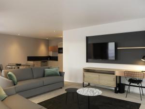 Una sala de estar con un sofá y un televisor en una pared. en Aparthotel & Spa Adagio Vannes, en Vannes 81 fotos más