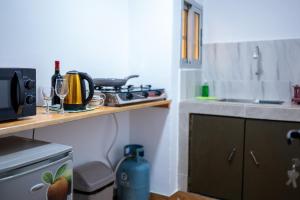una cucina con un lavello e un bancone con un fornello di Green Haven - Modern Cozy Studio - Fast Wi-Fi - AC - Cocody a Abidjan