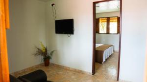 a room with a tv on the wall and a mirror at Pousada Plenamar in Maragogi