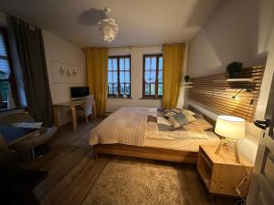 a bedroom with a bed and a desk and windows at Dako Mansion, Stylish, Modern, Cosy in Rzeszów