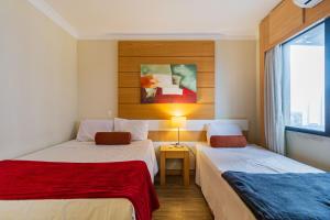 Una habitación de hotel con dos camas y una ventana. en Flat próximo Aero Congonhas, en São Paulo 12 fotos más