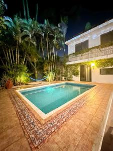 a swimming pool in front of a house at night at Cozy Apartment for 2 with Pool Access in Chuburná de Hidalgo