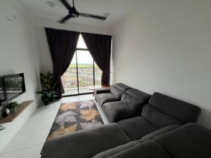 a living room with a couch and a large window at I&M Staycation in Alor Setar
