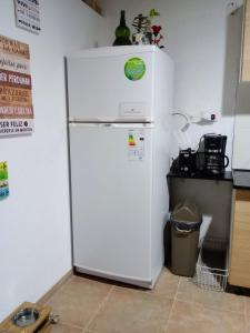 a white refrigerator in a kitchen with a trash can at Elmosquetal in Villa Yacanto