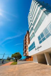 un grande edificio bianco con finestre sul lato di Descanso & Mar a Capão da Canoa