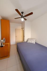 una camera con letto blu e ventilatore a soffitto di Descanso & Mar a Capão da Canoa Altre 17 foto