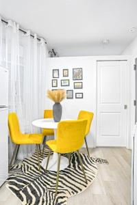 une salle à manger avec une table et des chaises jaunes dans l'établissement Homelike suites in the heart of China Town, à New York