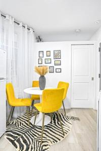 une salle à manger avec une table et des chaises jaunes dans l'établissement Homelike suites in the heart of China Town, à New York