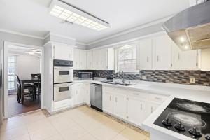 a kitchen with white cabinets and a dining room at Hot tub, Game and Movie Room ,15 Min to IAH Airport in Houston