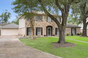a brick house with a tree in the yard at Hot tub, Game and Movie Room ,15 Min to IAH Airport in Houston