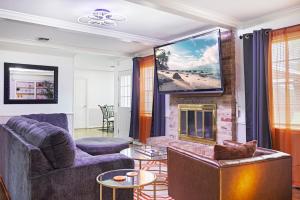 a living room with a fireplace and a tv at Hot tub, Game and Movie Room ,15 Min to IAH Airport in Houston