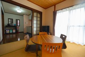 a dining room with a wooden table and chairs at MarunoStay-最大8名-プロジェクター完備-アクセス良好-岡山城後楽園徒歩圏内 in Okayama +42 photos
