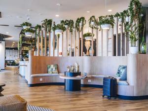 un vestíbulo con sofás y plantas en una tienda en ibis budget Rouen Centre Rive Gauche, en Rouen
